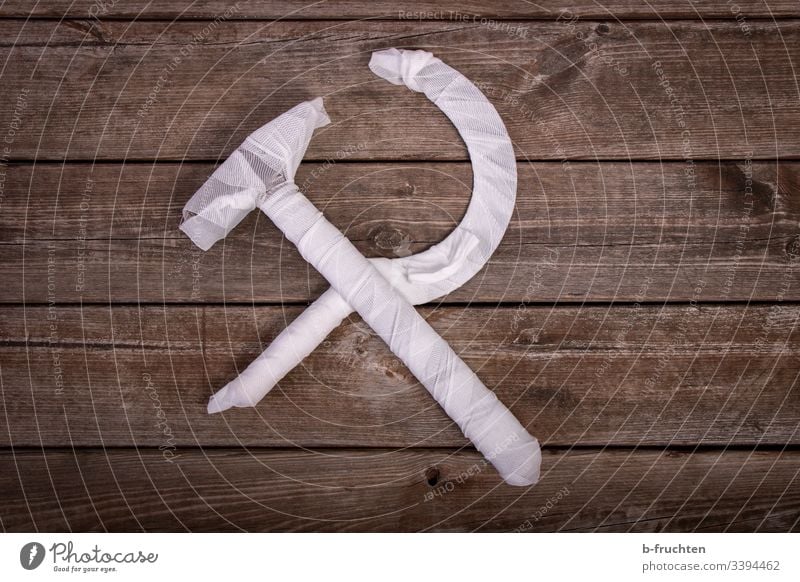 hammer and sickle bound on wooden boards Hammer Bandage First Aid symbol Rescue Communism Politics and state Sheath Encased in Protection White