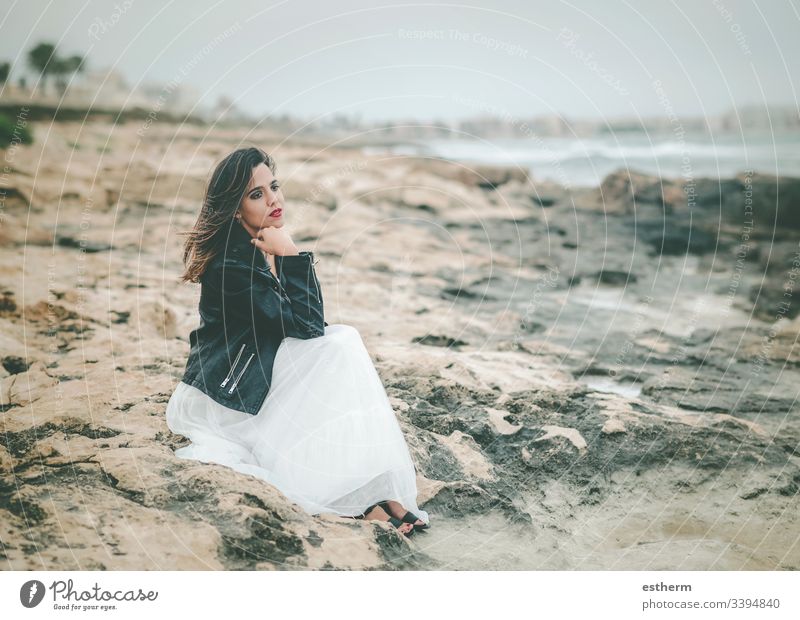 Pensive Young woman sitting on the beach young woman beautiful elegant elegance dream dreaming dreams dress fashion freedom fun glamor independence joy