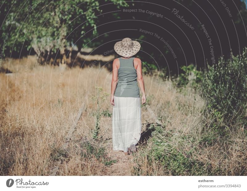 Back view of a Pensive Young Woman in the field young woman dreaming dreams freedom grass in love love landscape leisure lifestyle beautiful loneliness lonely
