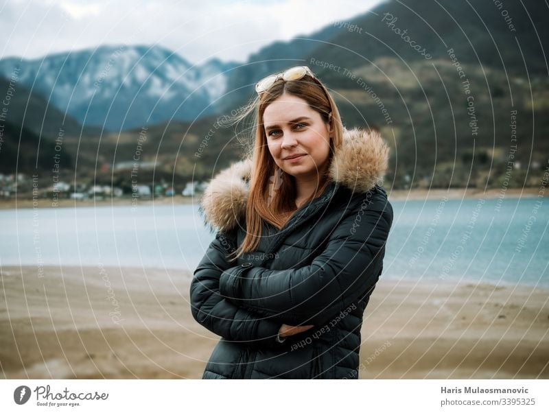 Young beautiful blonde woman in nature lakeside and mountain top in background adult adventure attractive beauty caucasian cold copy space cute dust face