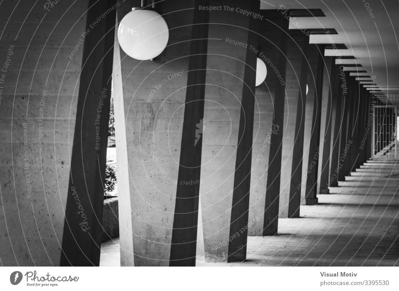 Outdoor hallway with columns in black and white grayscale photography greyscale contrast lamps outdoor exterior structure perspective abstract repetition