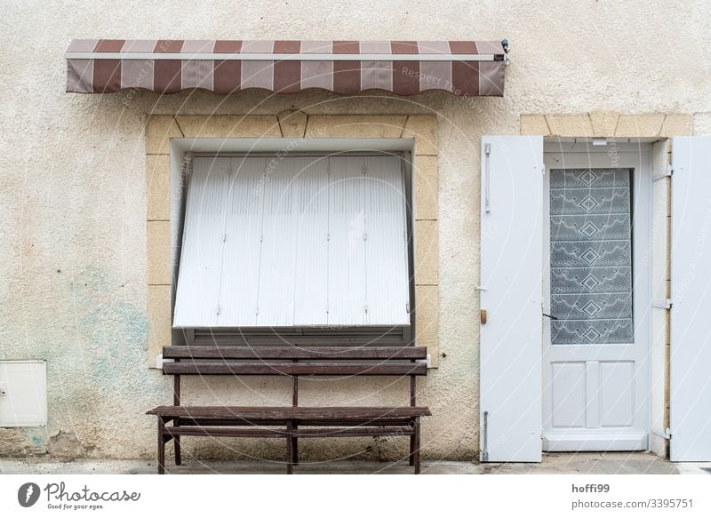 Still life of an old town facade with bench and closed shutter Old town Building Broken Wall (barrier) Roller shutter off Deserted Facade Architecture