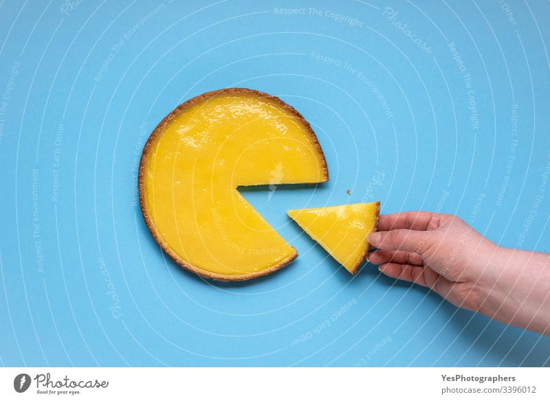 Taking lemon pie slice. Sliced lemon cake above view blue background citrous tart colorful cuisine delicious dessert eating flat lay fruit cake grabbing hand