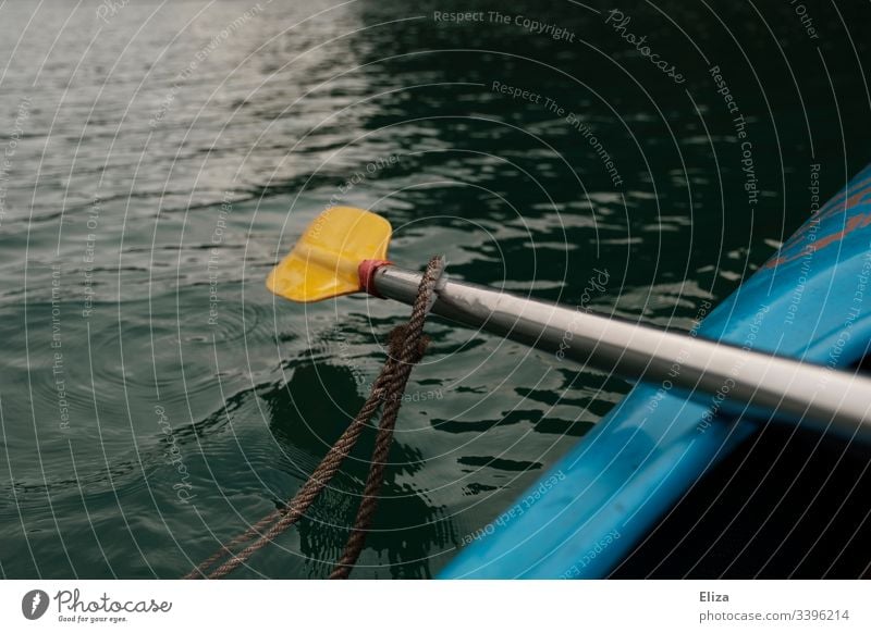 A yellow paddle sticking out of a blue kayak on the sea Paddle Kayak Ocean Sports Water Rowing Yellow Movement Exterior shot Vacation & Travel Aquatics