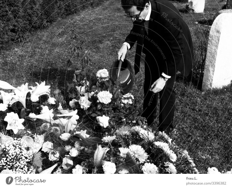 Something could still be done for the old man, he thought, and watered the flowers on the fresh grave. Grave Cemetery Grief Funeral Exterior shot Death Sadness