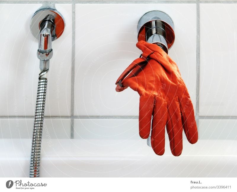 He couldn't remember how the orange glove had got on the tap, but he was now quite happy to dangle over the bathtub. Orange Bathtub Dry Clean Colour photo