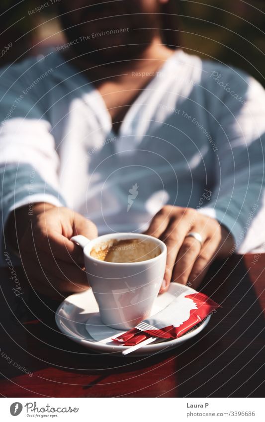 Man in white blouse holding a cup of coffee close up man hands cappuccino espresso beverages morning breakfast relax relaxation drink