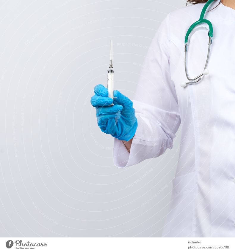 medic woman in white coat and blue latex gloves holding a syringe, white studio background adult care caucasian clinic cure doctor dose drug equipment female