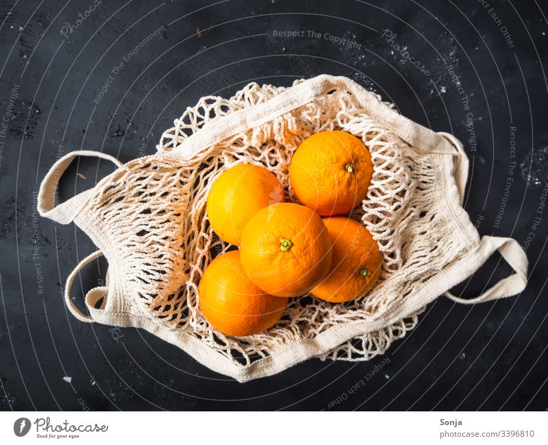 Draufsicht auf frische Orangen in einer wiederverwendbaren Einkaufstasche auf einem schwarzen Hintergrund Frische einkaufstasche draufsicht orange color Fruit