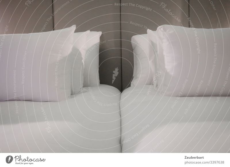 Double bed in a hotel, with white pillows in front of a grey back wall, awaits the travellers Bed Bedclothes Cushion Hotel crack Bedroom Pillow Sheet Sleep