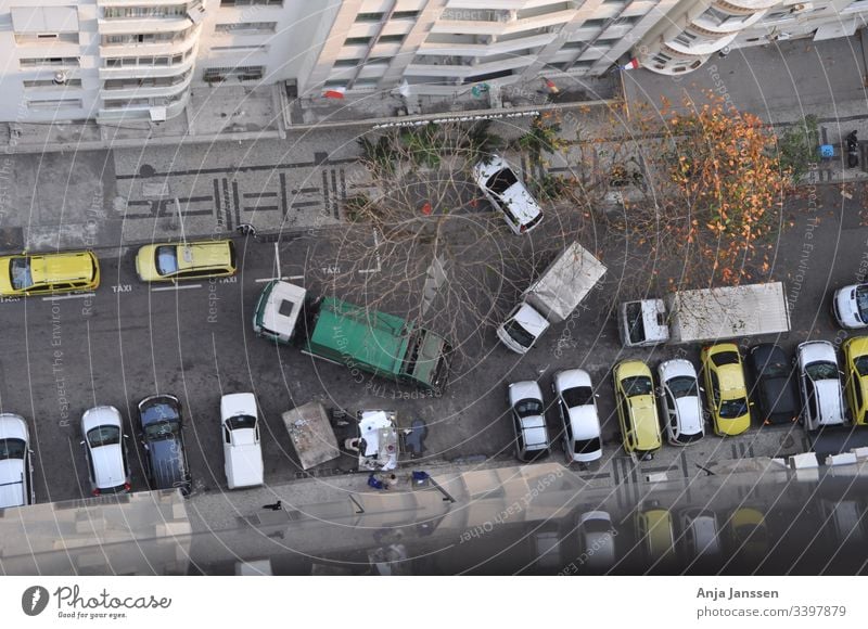 Aerial view of a side street with everyday traffic, garbage collection and parked cars at the roadside in autumn Street secondary roads aerial photograph