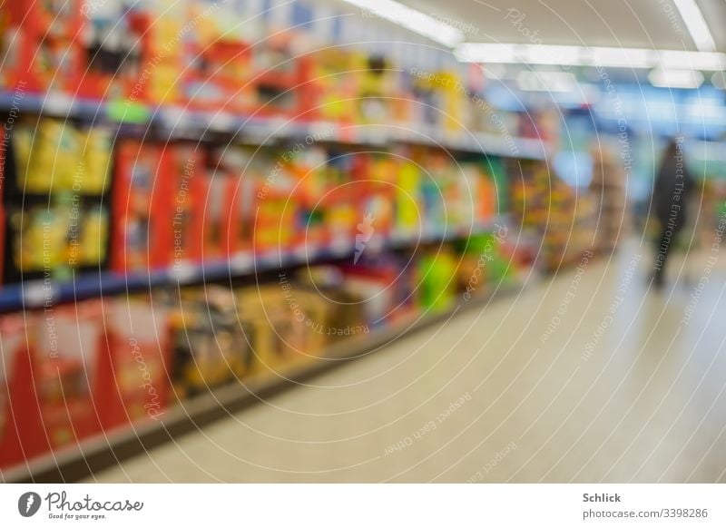 Blurred, colourful, full shelves in the supermarket and customer in the background Supermarket blurriness Shelves Customer buyer Consumption consumer motley