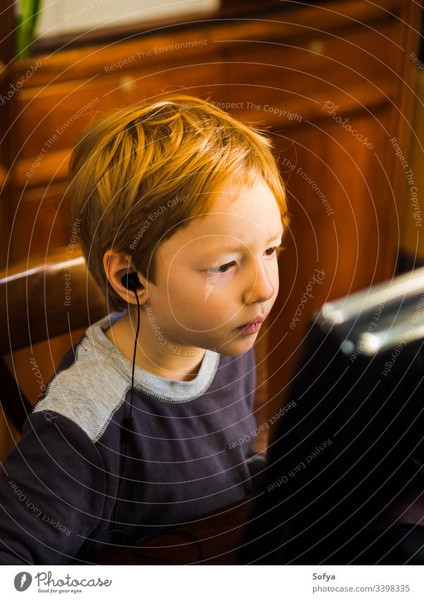 Cute little boy playing at pc with very concentrated face expression computer child kid technology internet leisure male person young lifestyle music modern