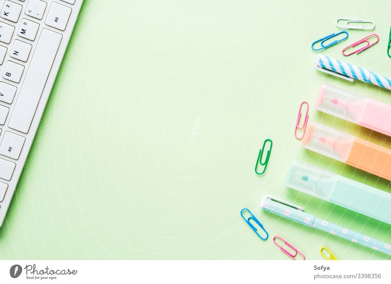 Mint green back to school flat lay concept frame with keyboard, colorful highlighters and clips stationery blogging sneakers blank computer shoes create
