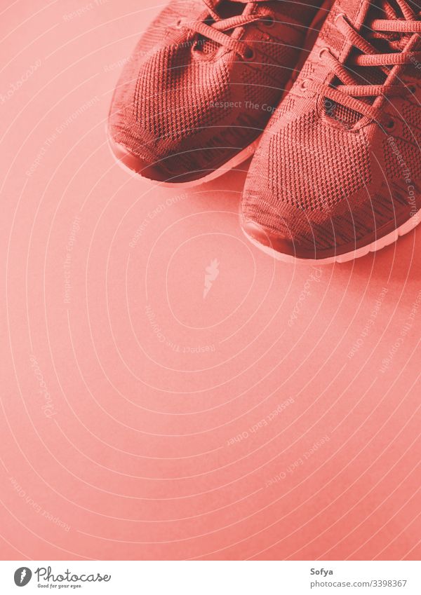 Sport trainers on empty background. Red coral tone - a Royalty