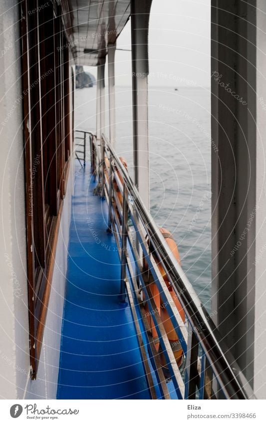 View over a passage of a ship over the railing with rescue tires to the water Ocean Water Railing rescue tyre Blue Wood seafaring Trip Gray foggy Exterior shot