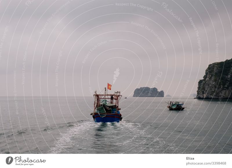 A ship on the sea in Halong Bay in Vietnam; beautiful landscape with limestone rocks rising out of the sea in foggy weather Halong bay Ocean Limestone rocks