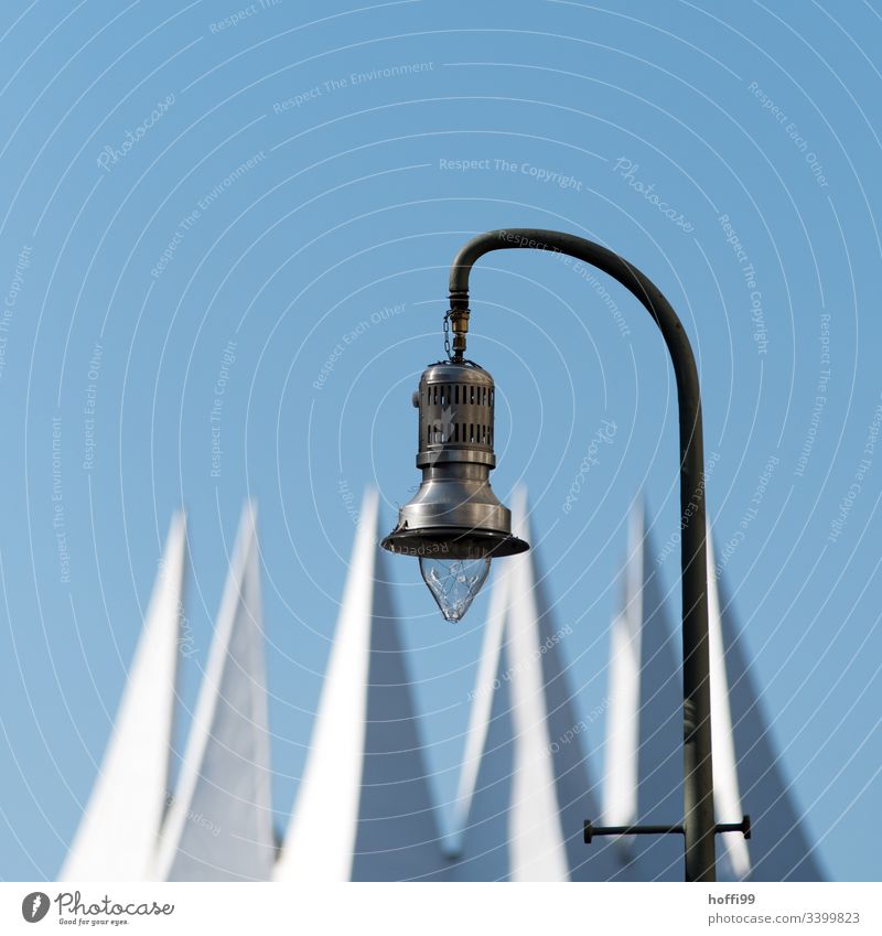 View of a street lamp against deep blue sky and white crown Minimalistic Lamp Street lighting Lantern Flag flag Blue sky Blue background Summer Exterior shot