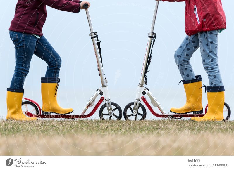 Scooter wheel to wheel with yellow rubber boots scooter Rubber boots Yellow Playing children Toys Playground Duel