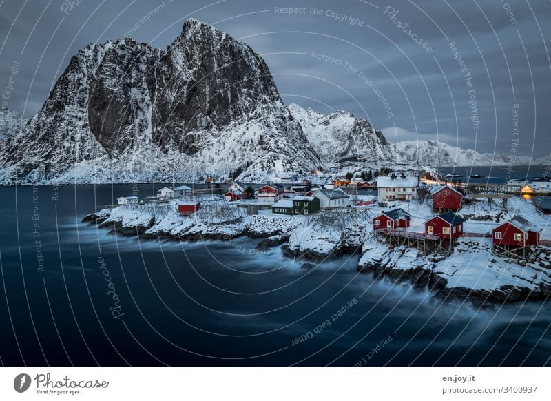 Hamnoy on the Lofoten with a view of the small red houses standing on snowy rocks at the blue hour Vacation & Travel Trip Winter Snow Winter vacation