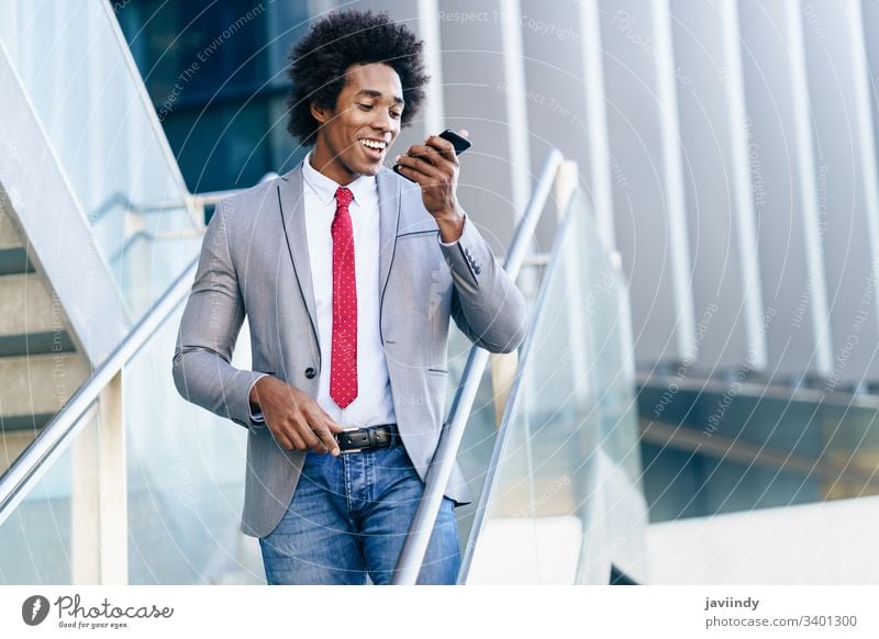 Black Businessman using a smartphone near an office building black businessman curly afro you hair suit african male adult portrait american person device