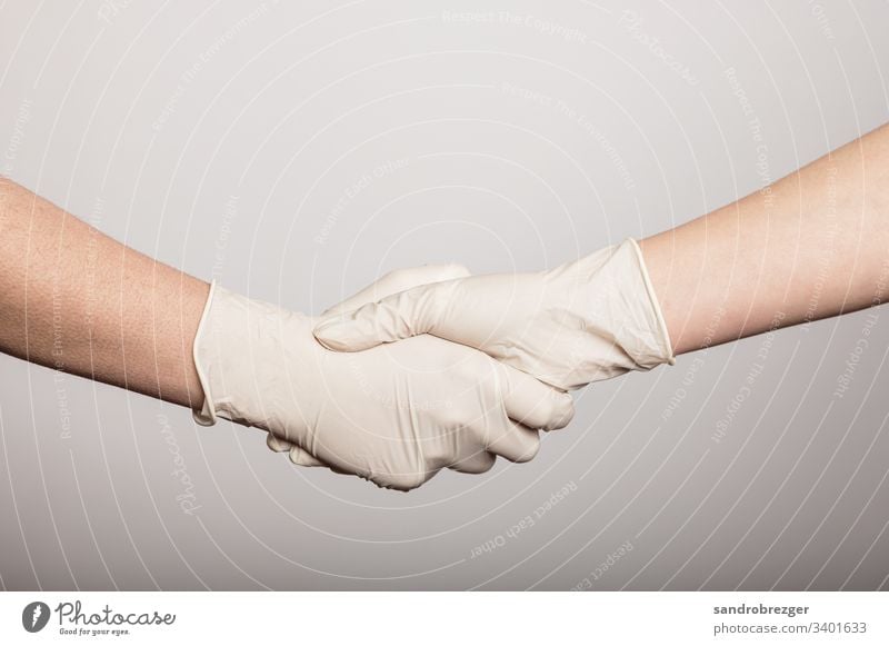 Handshake in times of the Corona Virus coronavirus covid-19 Illness pandemic Epidemic Mask guard sb./sth. disposable gloves hand protection Sterile Sick