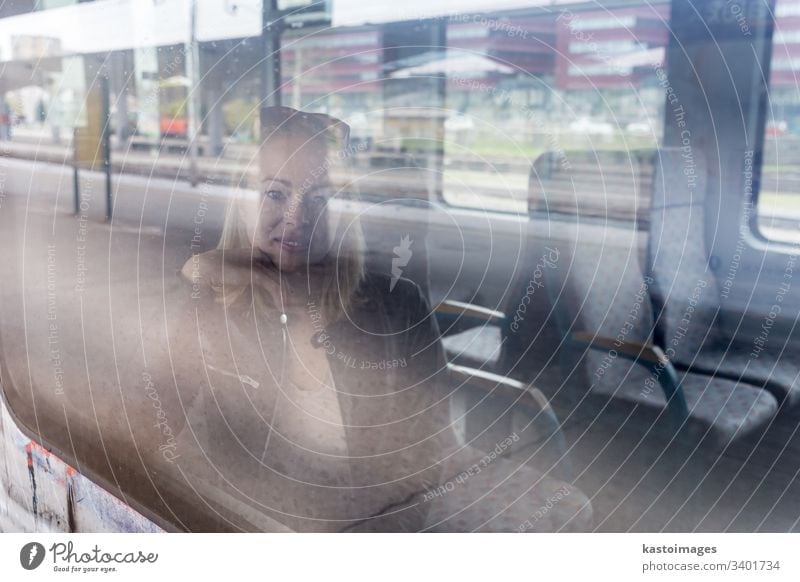 Young woman traveling by train, looking out window while sitting in train. girl young female passenger ride railway adult journey person transport