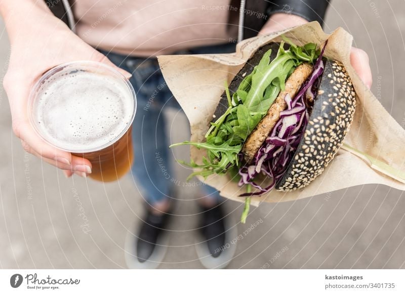 Female Hands Holding Delicious Organic Salmon Vegetarian Burger and Homebrewed IPA Beer. burger beer hands letuce eating salmon organic meat unhealthy woman