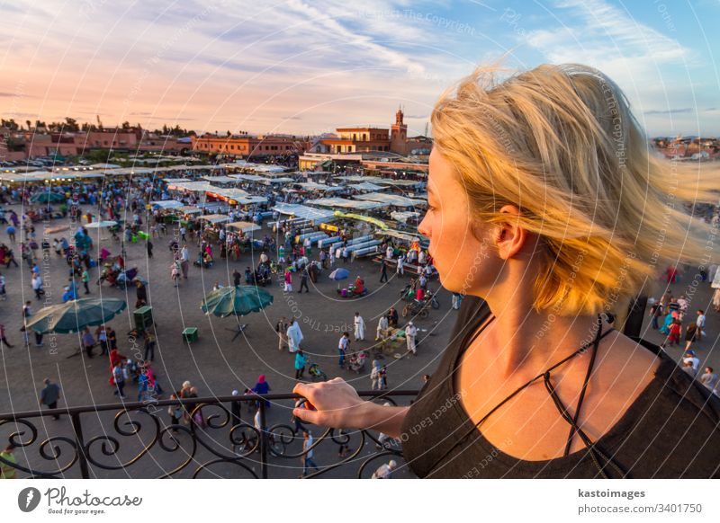 Woman overlooking Jamaa el Fna market square in sunset, Marrakesh, Morocco, north Africa. marrakesh morocco traveler tourist woman lady marrakech africa jamaa