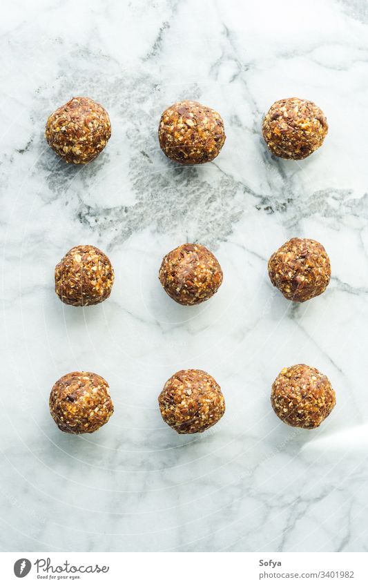 Energy balls with healthy ingredients, seeds and nut butter, on marble board table energy protein food vegan pattern dates peanut flax chia oats almond
