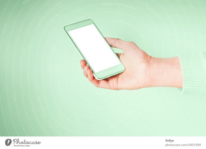 Hand with mobile phone and empty white screen on mint green color 2020 green mint neo using color year hands smartphone woman device internet connection