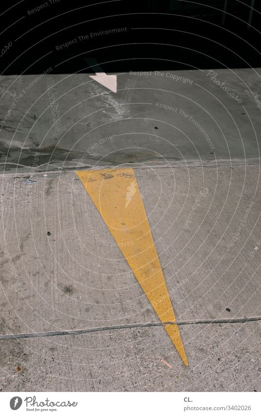 two arrows on the floor Arrow Ground Direction Trend-setting Orientation Yellow Gray Right ahead Colour photo Sign Deserted Signs and labeling Exterior shot