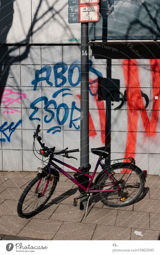 a bicycle is on the sidewalk off Graffiti Dirty Bicycle Wall (building) Traffic infrastructure Colour photo Exterior shot Deserted Lanes & trails Transport
