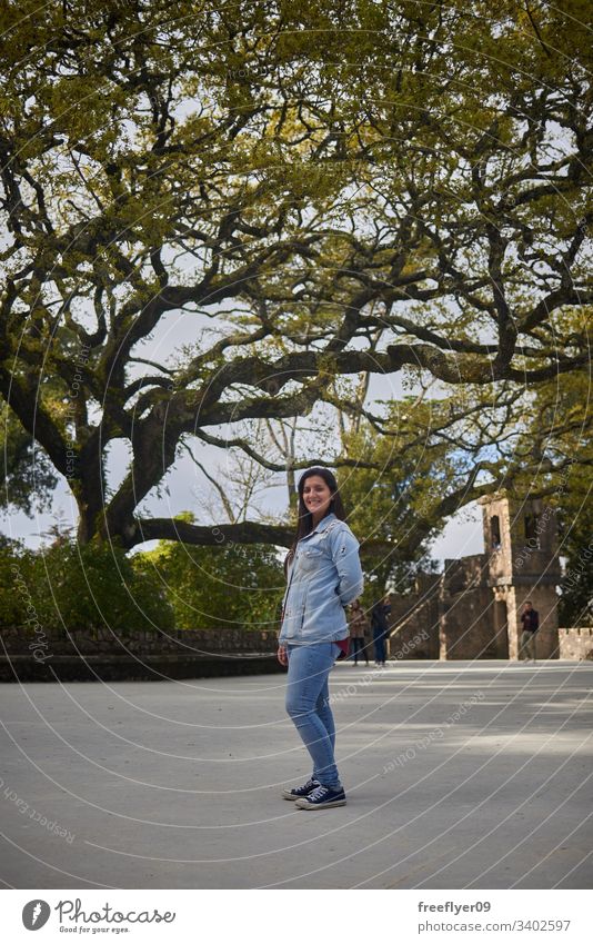 Young woman on Regaleira, Sintra, Portugal young tree tourism tourist forest park famous historic nature path landscape hiking hike grass palace art europa red