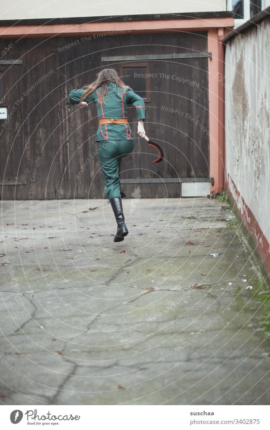 teenager in uniform jumps over in the courtyard with a sickle in his hand Girl Young woman Youth (Young adults) Puberty Uniform Suit Hammer Tool Wooden gate