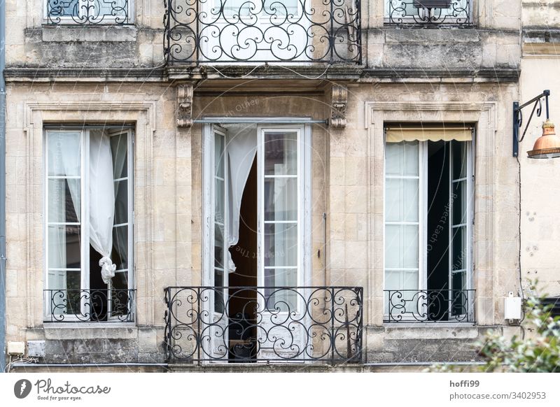 elegant old building balcony with open windows and waving curtains Window Shutter Row Quarrystone facade Wall (barrier) Wall (building) arched window