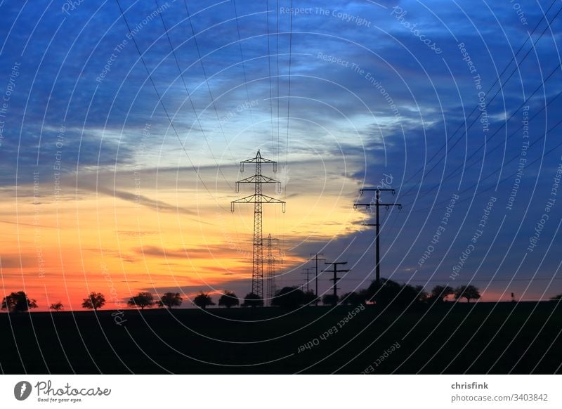 Power line in evening sun stream mast high voltage High voltage Energy Electricity Technology Cable Energy industry Sky Colour photo Electricity pylon