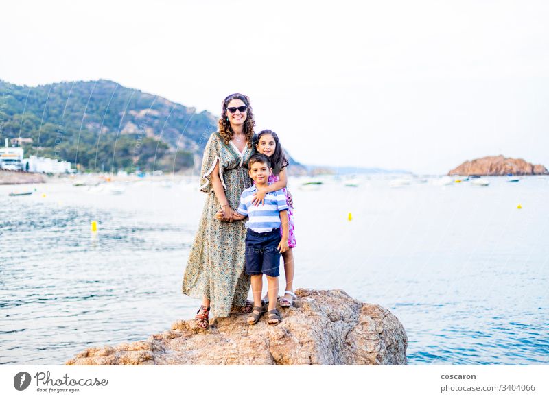 Mother and children in a rocky coast authentic beach cape caucasian childhood cliff daughter dress family girl happiness happy hiking holiday hot kid landscape