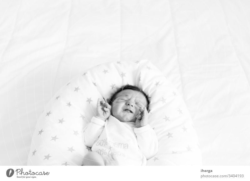 black and white image of baby crying on a bed background beautiful born boy caucasian cute down expression eyes head health healthy human indoors infant life