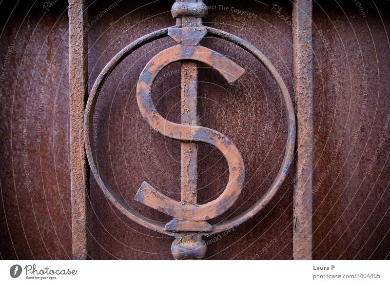 Close up of an iron $ dollar sign, decoration on a gate close up rusty grudge metal metallic old detail background iron bars