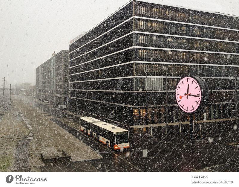 Clock in snow clock time Clock face Winter bus city blizzard hurry time change lack of time Exterior shot haste Digits and numbers lunch-time buildings offices