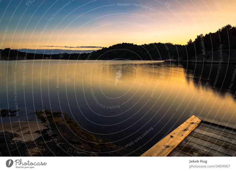 Sunset in a small fjord in Norway Night shot boat Boating trip Beach Coast Lakeside River bank Hiking Vacation in Norway Small Town Dark Fire Contrast