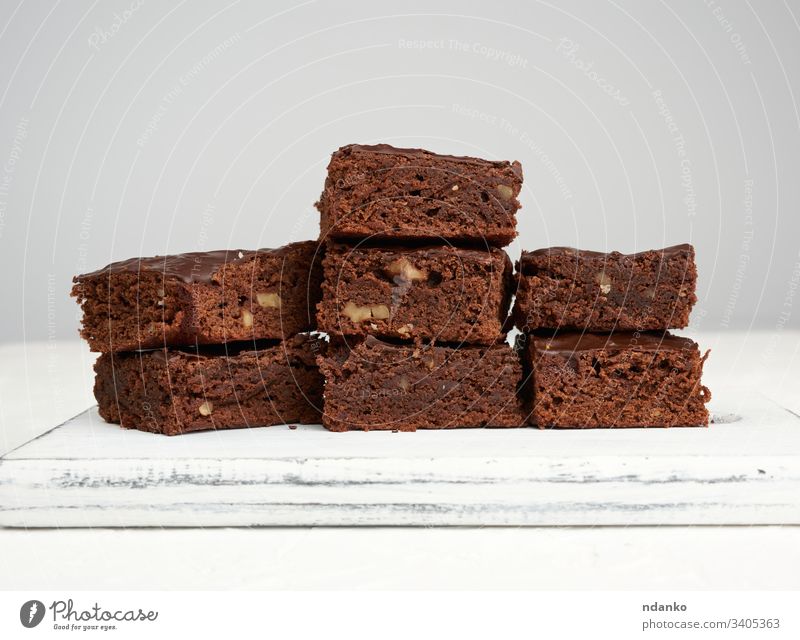 stack of square baked slices of brownie chocolate cake with walnuts bakery baking black closeup cocoa cooking cuisine dark delicious dessert eat food fresh