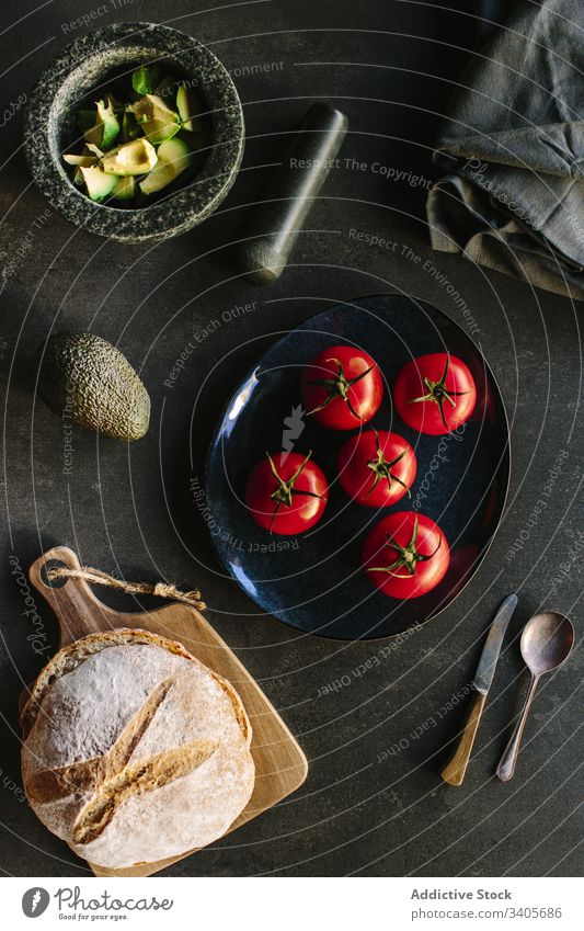 Fresh ingredients placed near kitchenware fresh guacamole cook tomato avocado bread napkin mortar pestle food organic cuisine composition healthy table