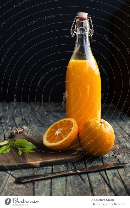 Orange juice in a bottle orange halves fresh vegan table kitchen summer vitamin fruit citrus exotic mix ripe healthy drink beverage knife natural organic