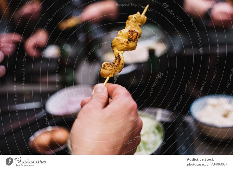 Crop person with chicken skewer dinner eat food restaurant dish tasty portion try meal delicious yummy snack cuisine appetizing lunch gourmet cafe cafeteria