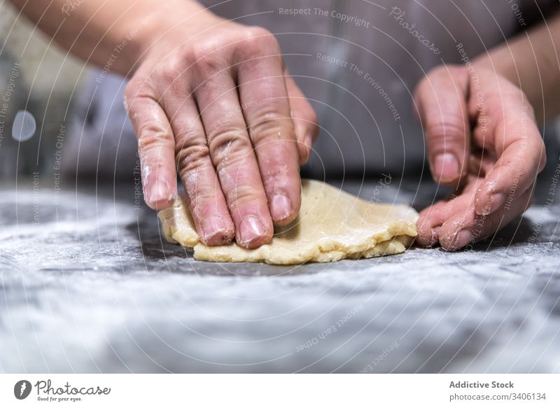 Crop baker rolling jam into dough cook pastry table flour bakery work chef kitchen food prepare fresh cuisine ingredient recipe occupation job small business