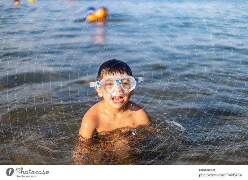 Funny kid with diving goggles on the beach active activity blue boy cheerful child childhood cute diver expressive fun happiness happy holiday holyday joy laugh