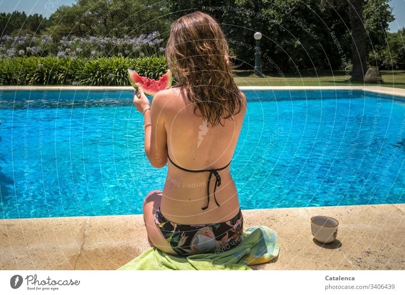 The young woman with the wet hair at the edge of the pool is eating a slice of watermelon food Nutrition Water melon Summer swimming pools Food Vegetarian diet