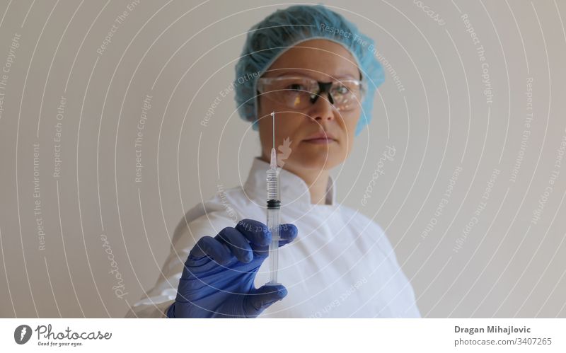 Female doctor holding a injection in hand anesthetic antibiotic arm asian woman biology care chinese clinic close-up closeup coronavirus dose drug equipment
